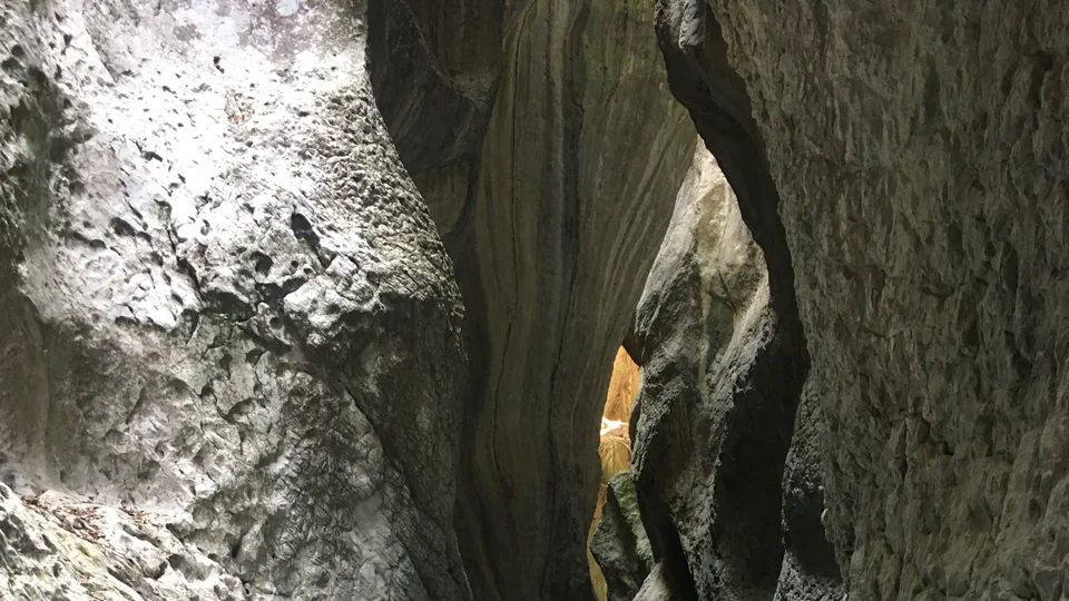 The Holta River flowing over smooth stones between the canyon walls